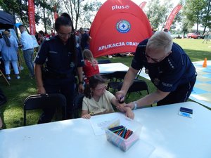 Policjanci podczas zabawy z dziewczynką.