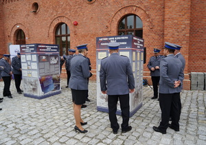 Policjantka i policjanci oglądają wystawę.