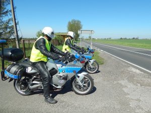 policjanci na motocyklach przy drodze