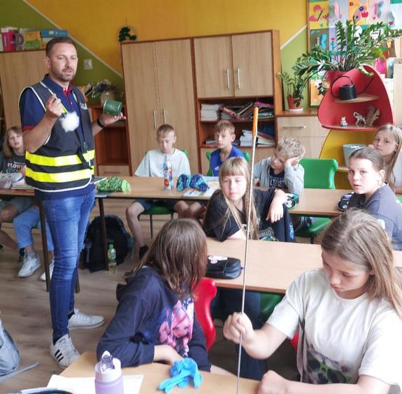 policjant i uczniowie na spotkaniu