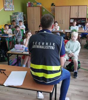 policjant i uczniowie na spotkaniu