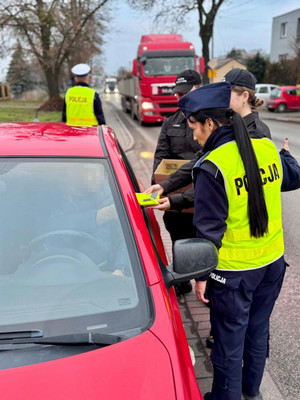 policjanci i uczniowie rozdają odblaski
