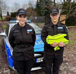 policjanci i uczniowie rozdają odblaski
