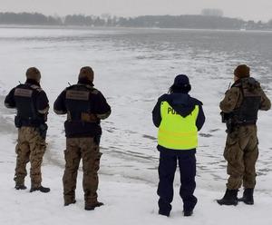 funkcjonariusze nad brzegiem jeziora
