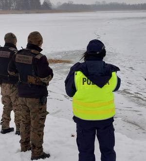 funkcjonariusze nad brzegiem jeziora